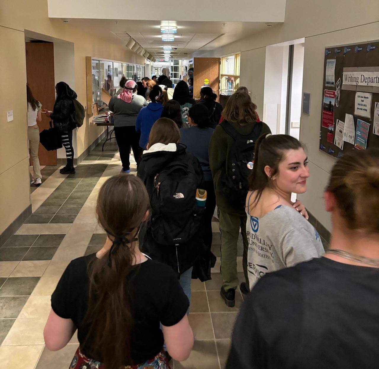 a line of students waiting for pizza